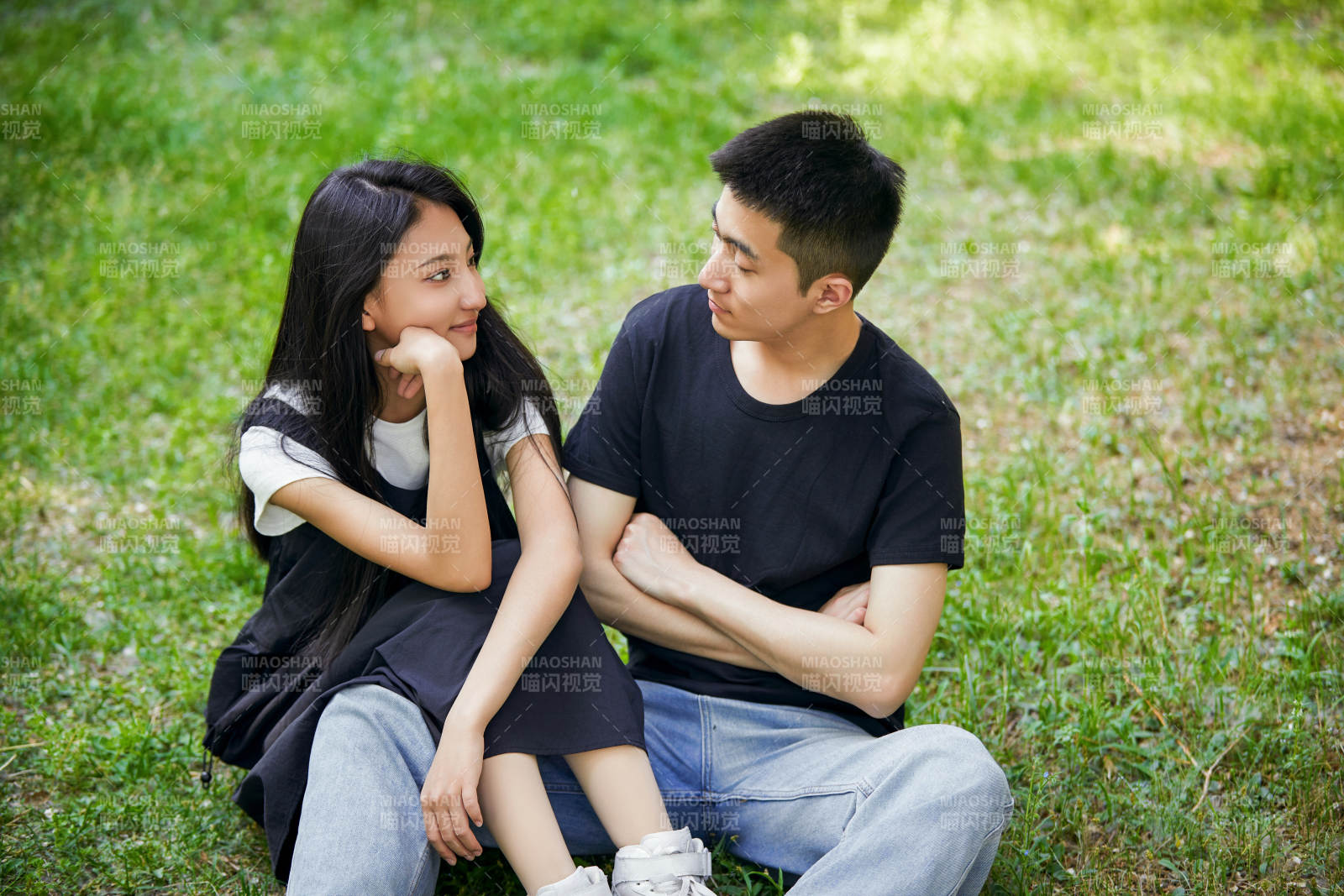户外草坪上的恩爱年轻情侣