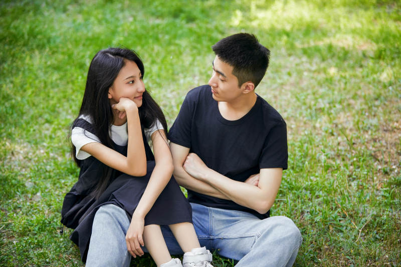 户外草坪上的恩爱年轻情侣