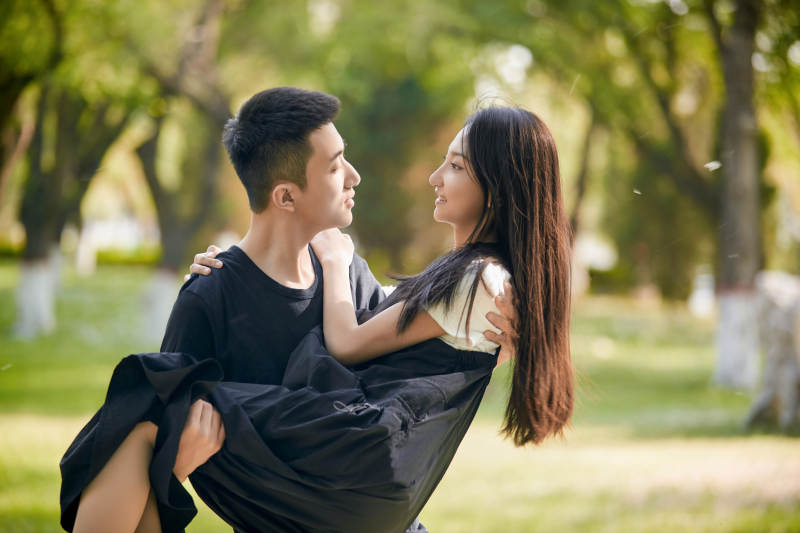 户外草坪上的恩爱年轻情侣