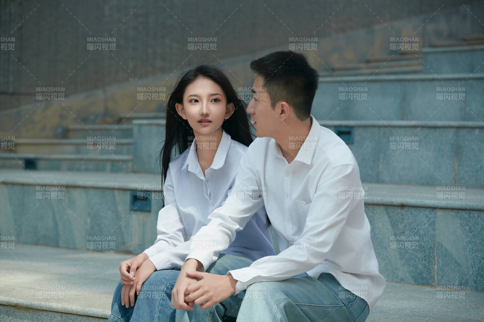 坐在户外台阶上的青年情侣