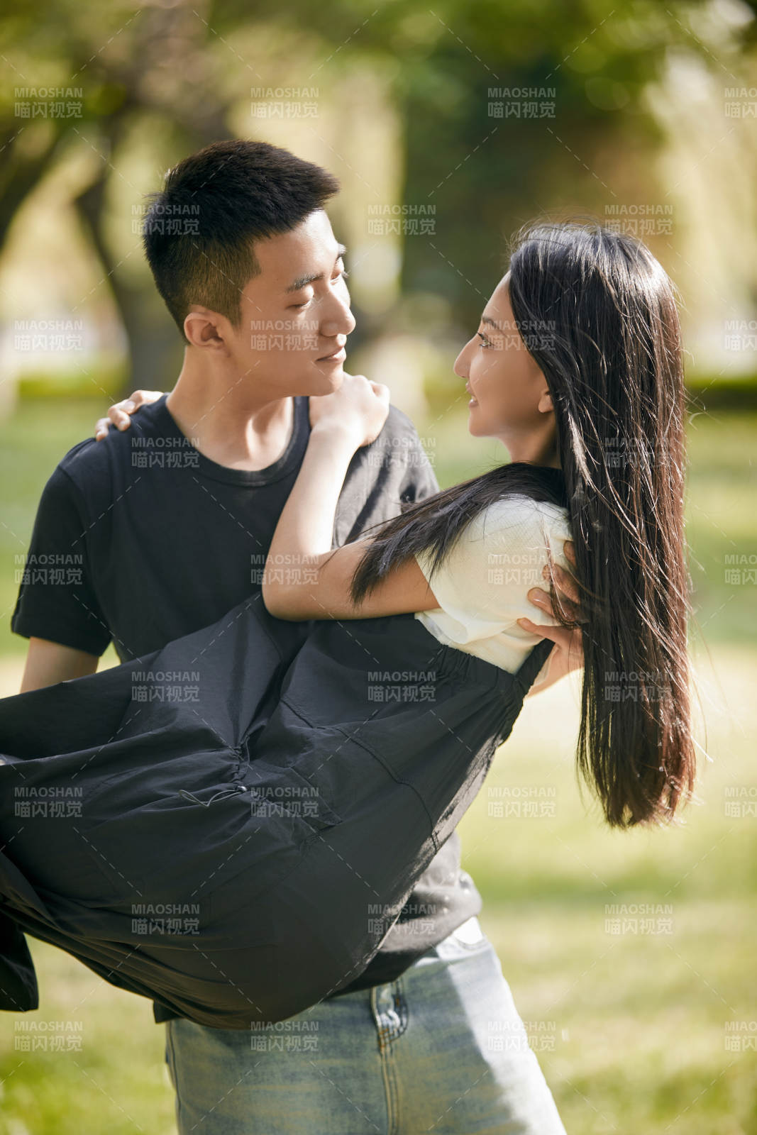 户外草坪上的恩爱年轻情侣