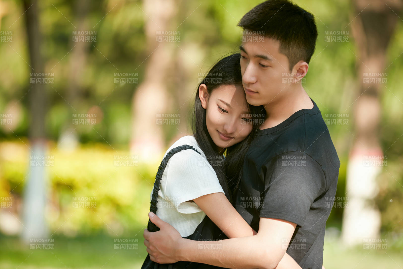 戶外草坪上的恩愛年輕情侶