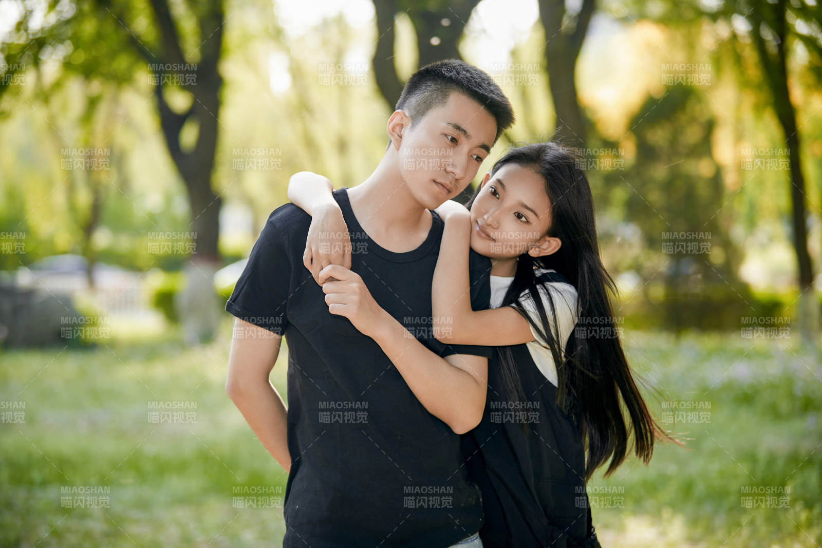 户外草坪上的恩爱年轻情侣