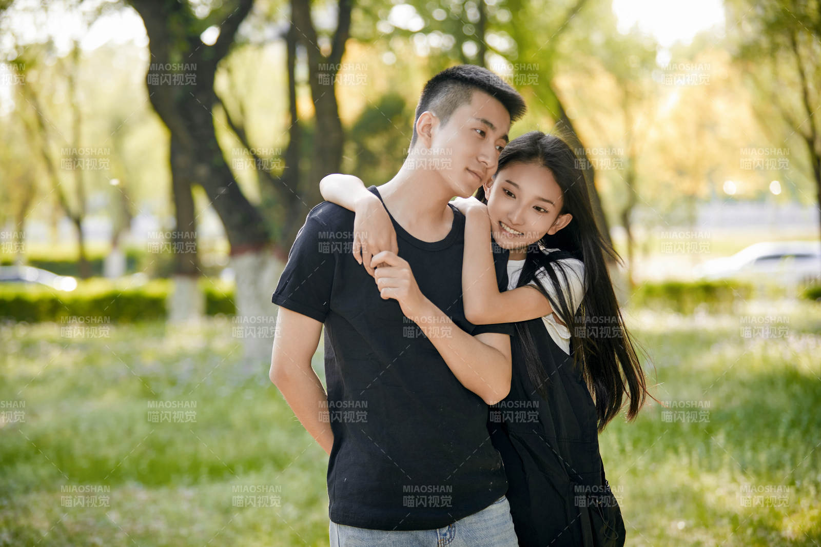 户外草坪上的恩爱年轻情侣