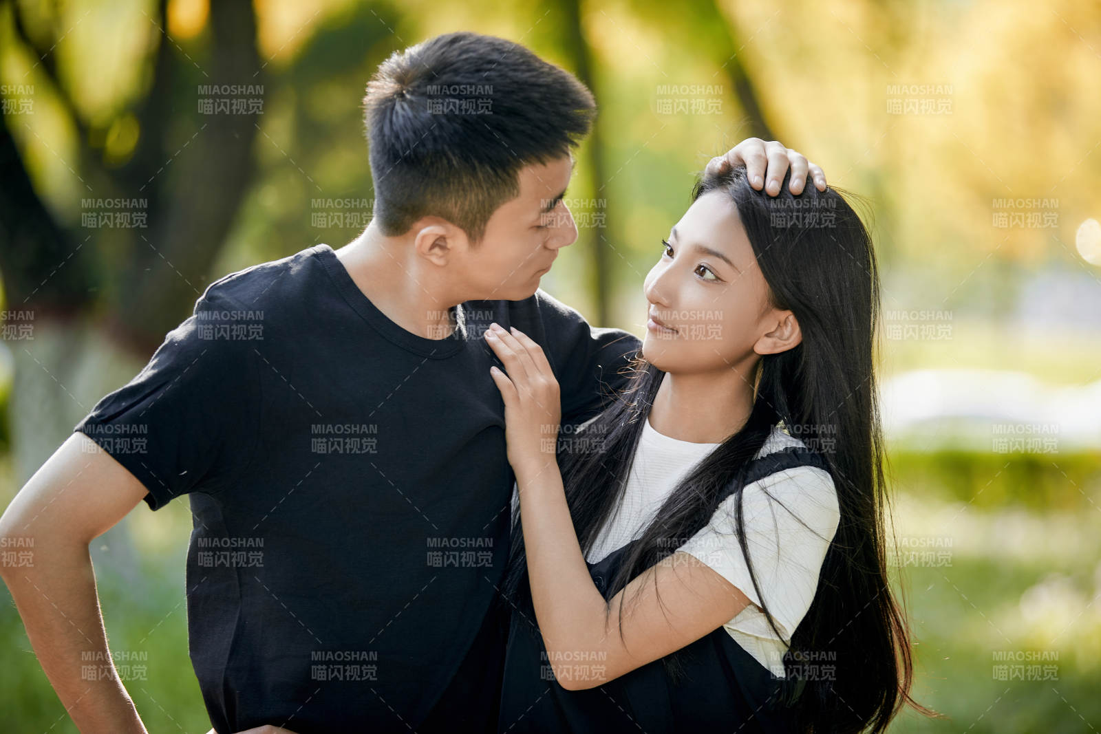 户外草坪上的恩爱年轻情侣