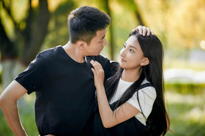 户外草坪上的恩爱年轻情侣