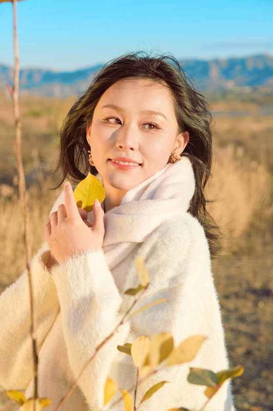 秋天午后在金灿灿的芦苇荡里的亚洲美女