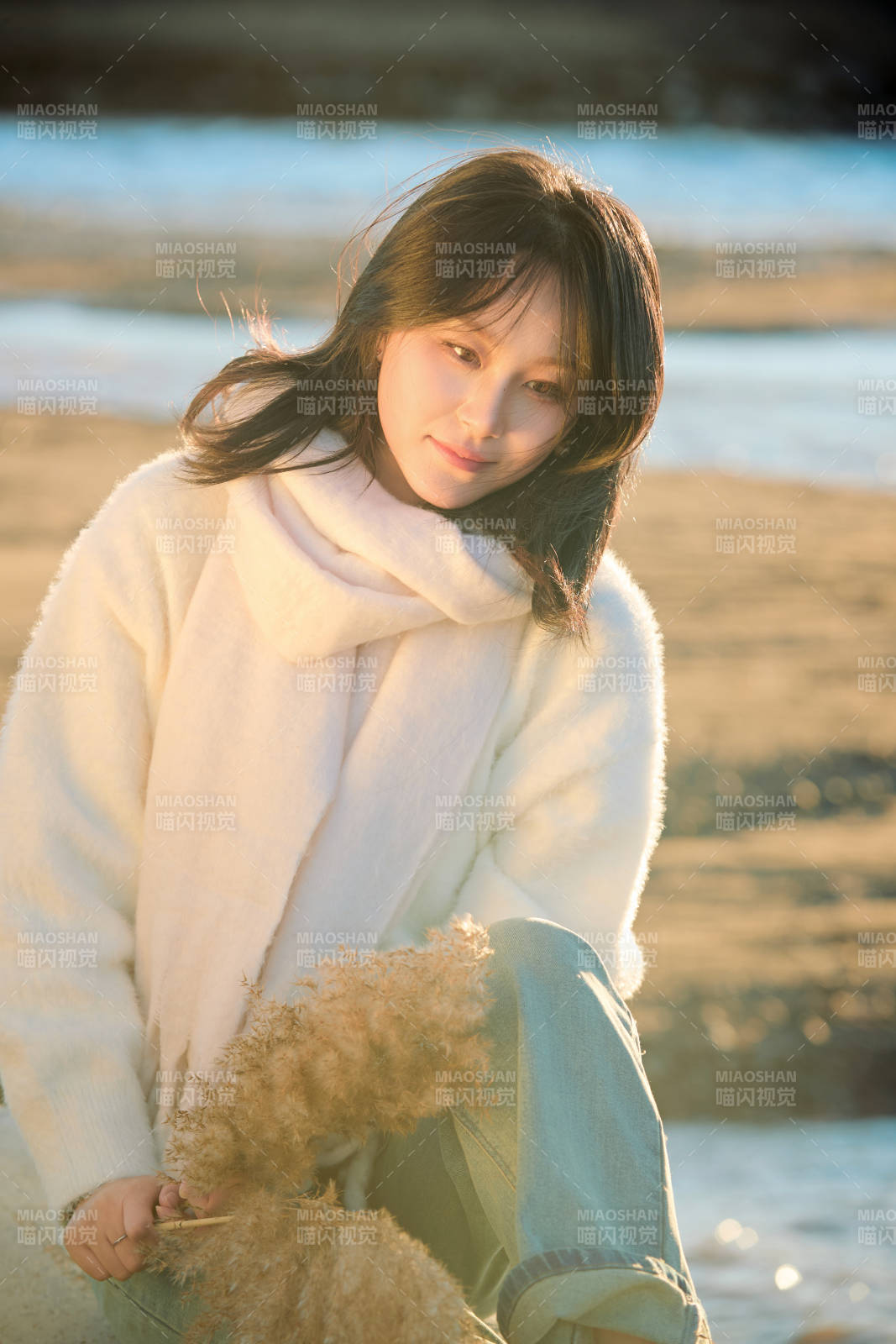 秋天在夕阳下的原野河边拍照的美女