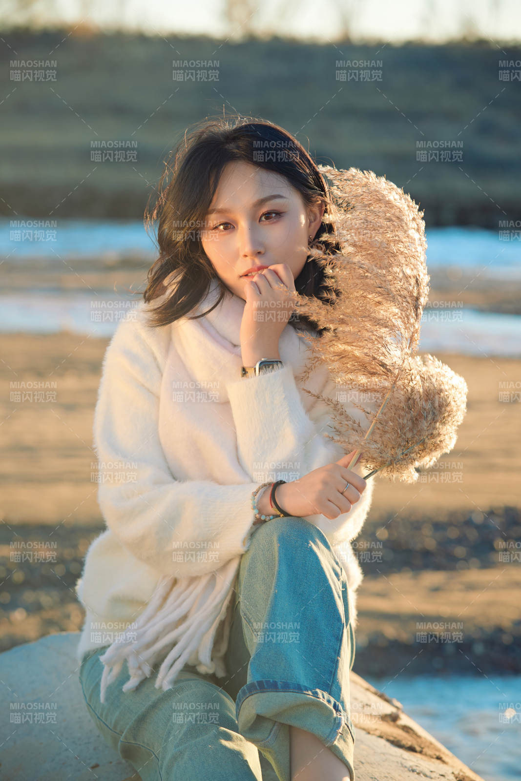 秋天在夕阳下的原野河边拍照的美女