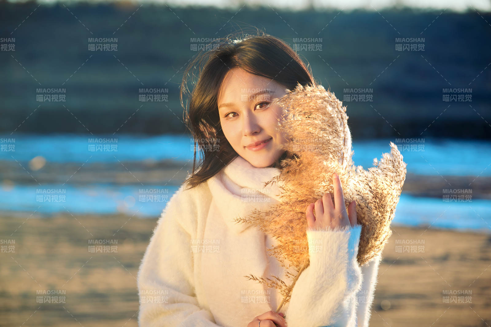 秋天在夕陽下的原野河邊拍照的美女