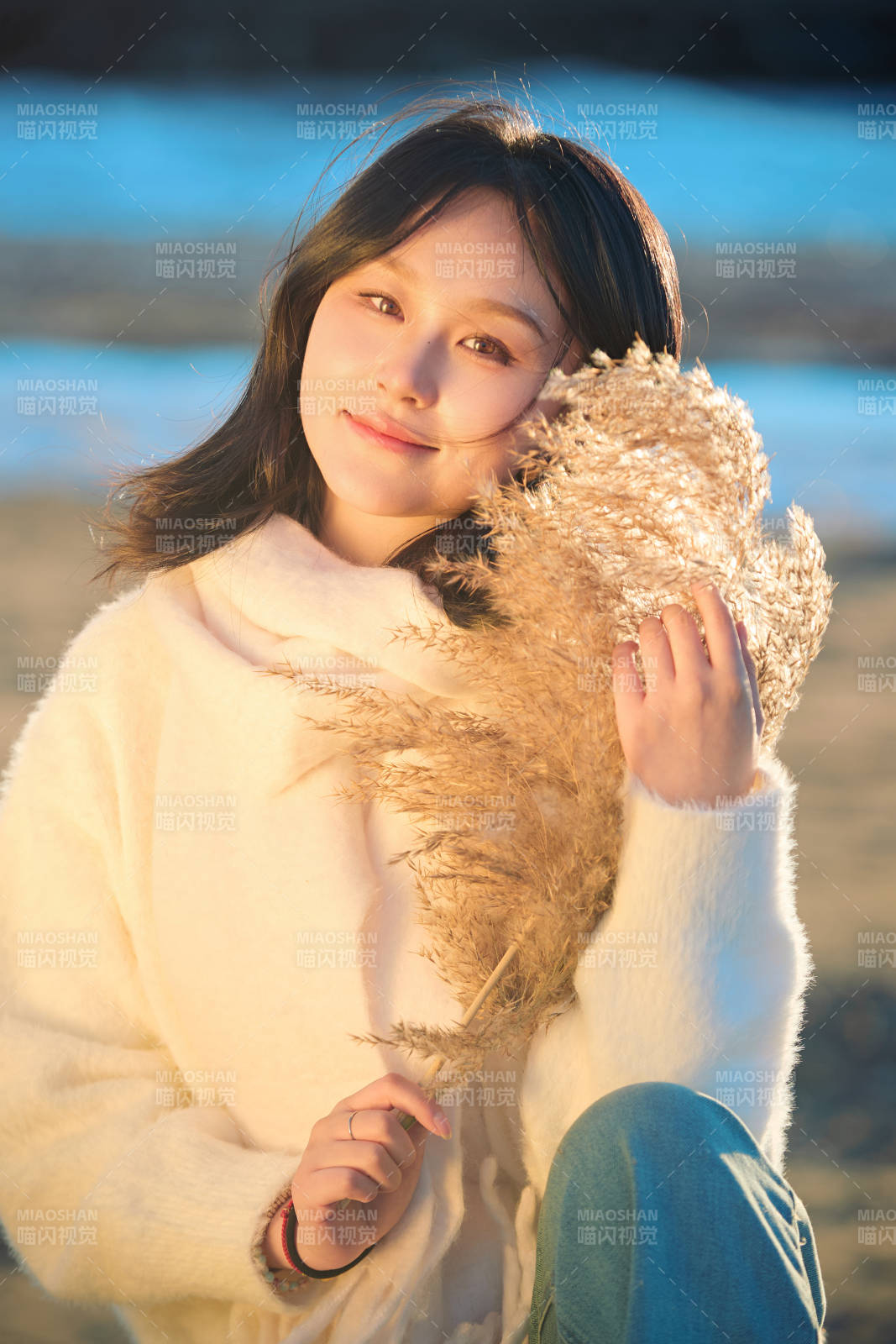 秋天在夕陽下的原野河邊拍照的美女