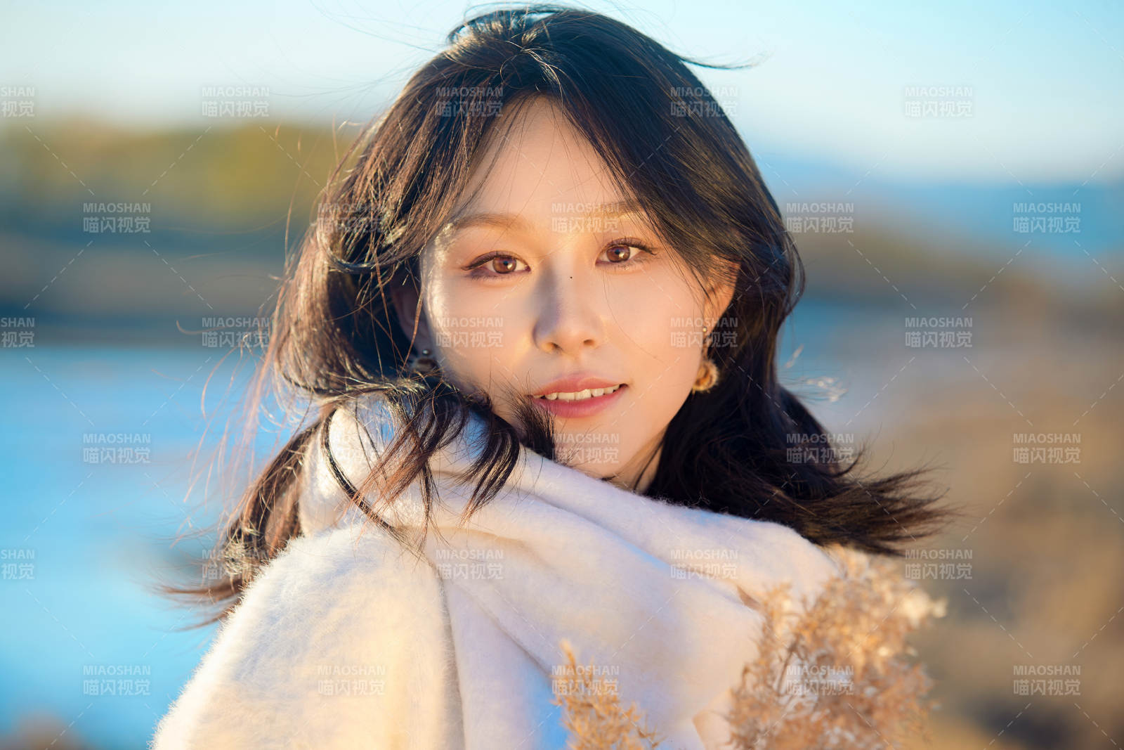 秋天在夕阳下的原野河边拍照的美女