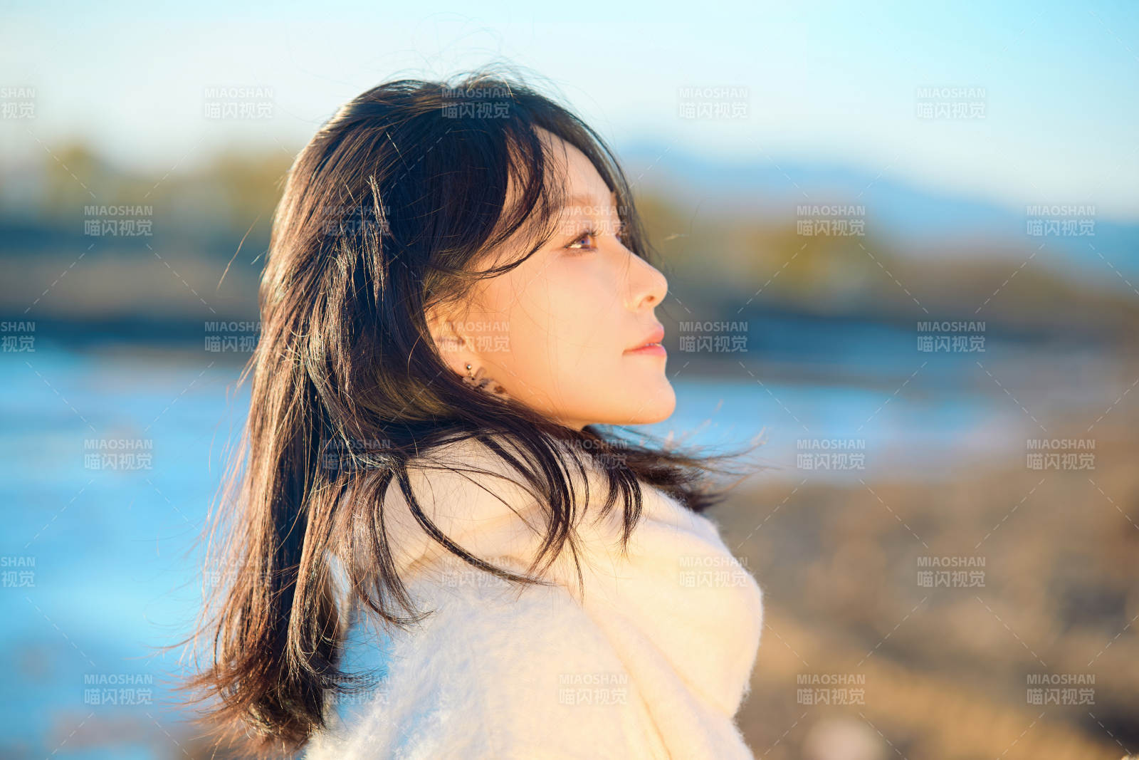 秋天在夕阳下的原野河边拍照的美女