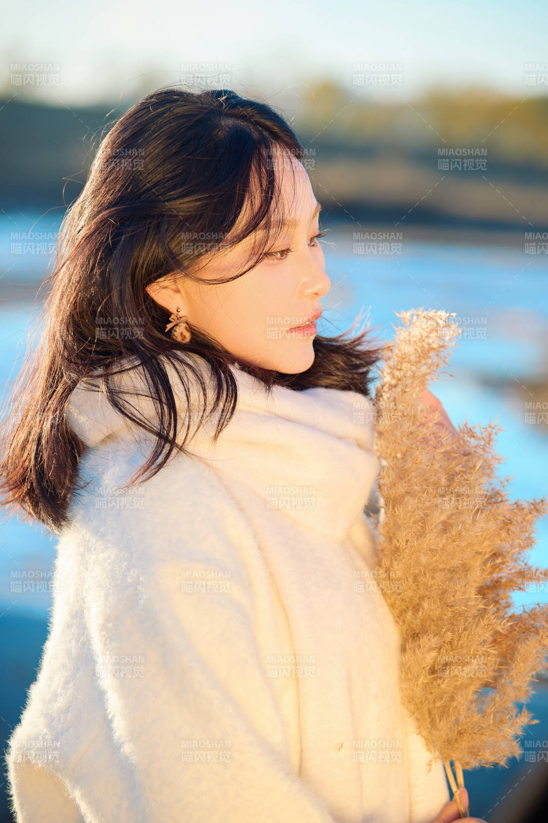 秋天在夕阳下的原野河边拍照的美女