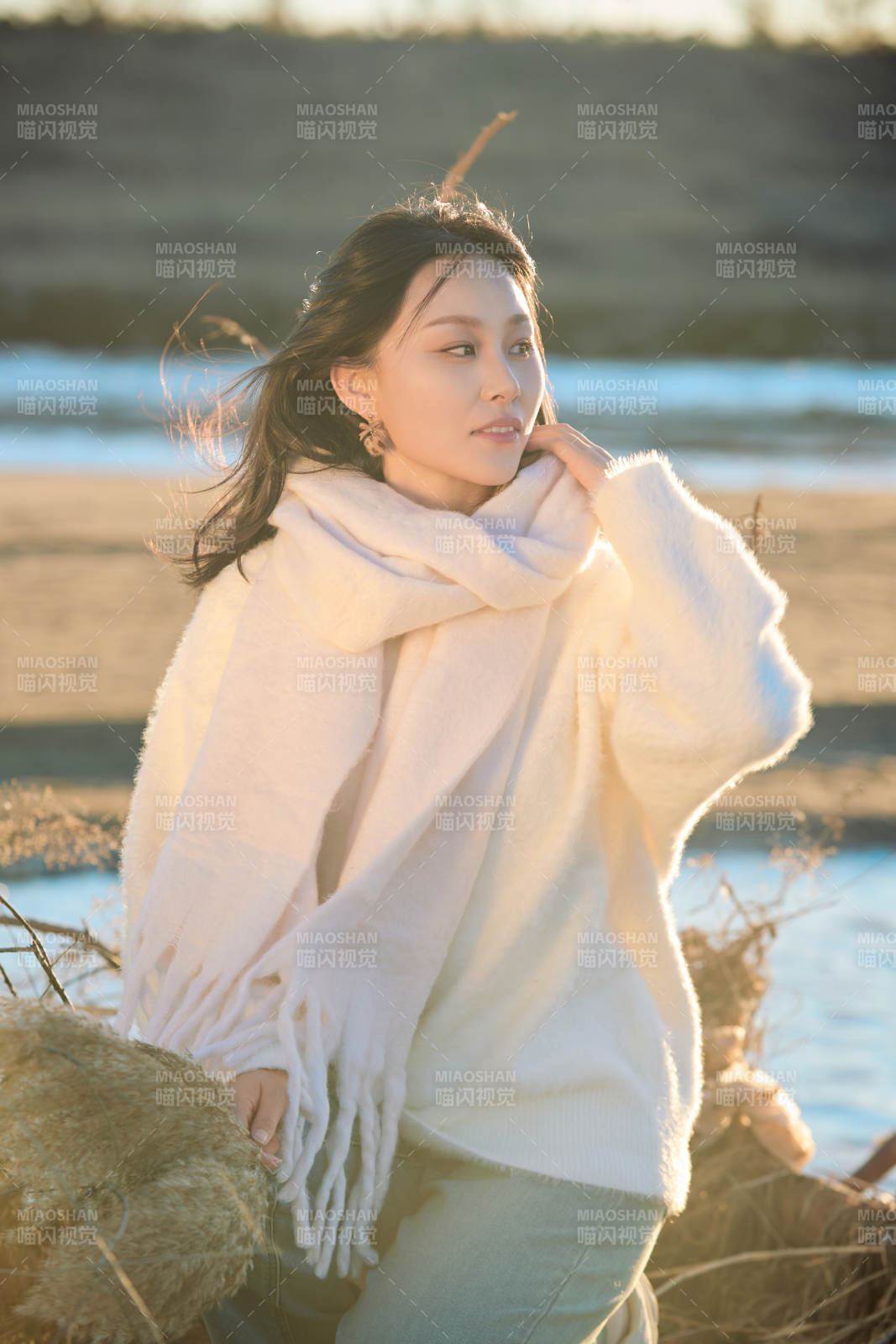 秋天在夕阳下的原野河边拍照的美女