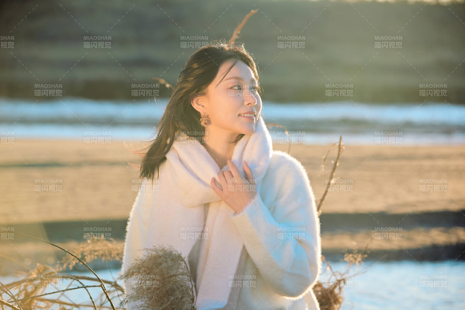 秋天在夕阳下的原野河边拍照的美女