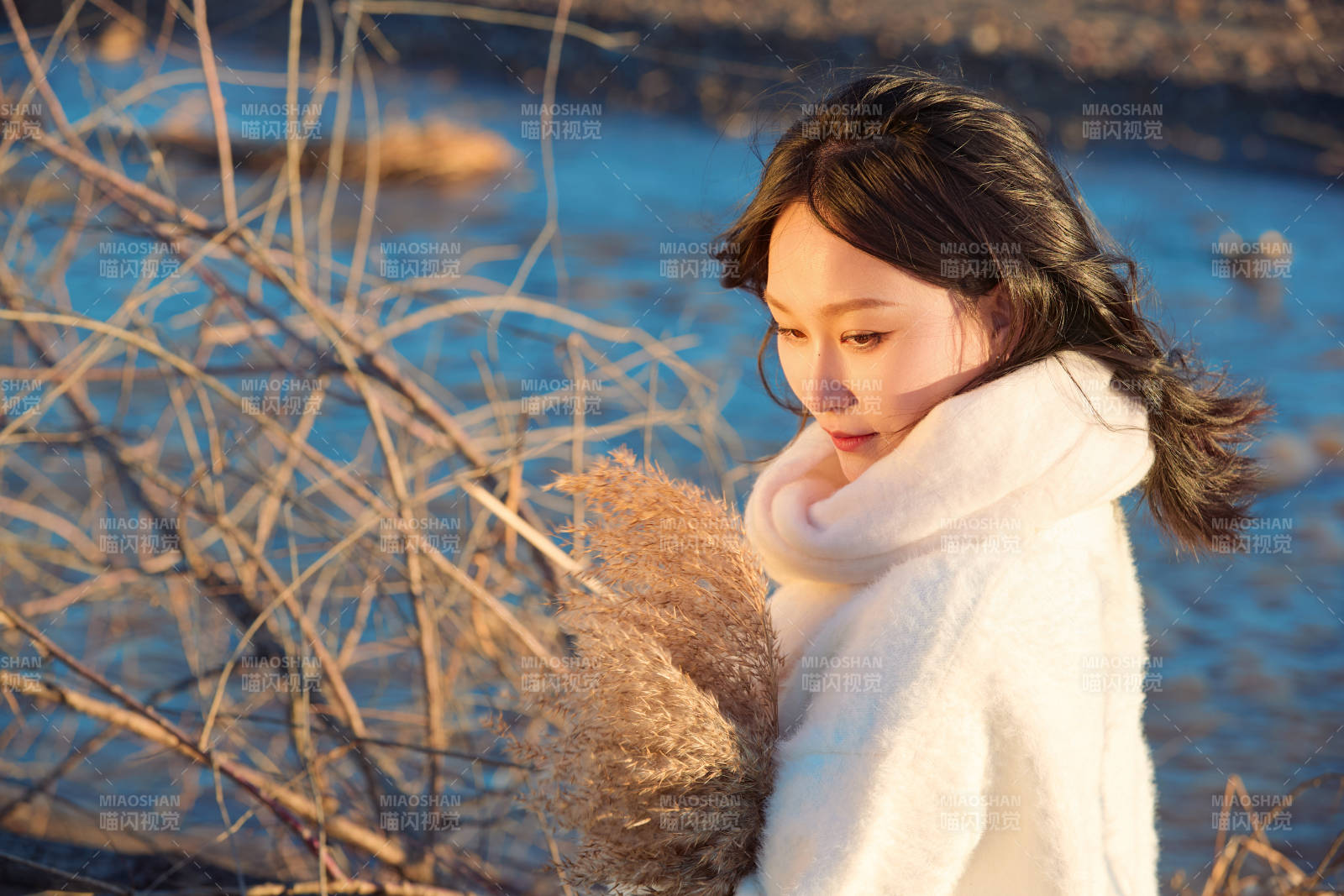 秋天在夕陽下的原野河邊拍照的美女