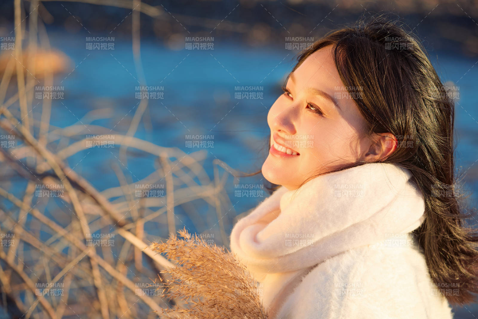 秋天在夕阳下的原野河边拍照的美女