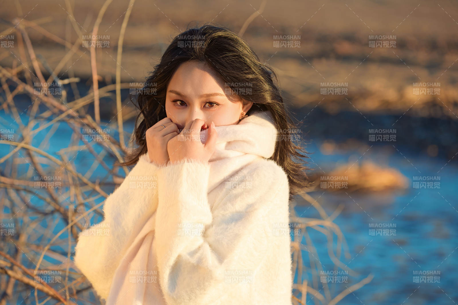 秋天在夕陽下的原野河邊拍照的美女