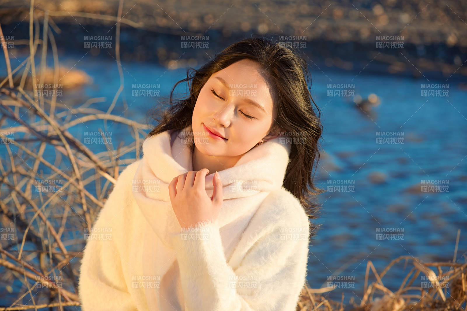 秋天在夕陽下的原野河邊拍照的美女