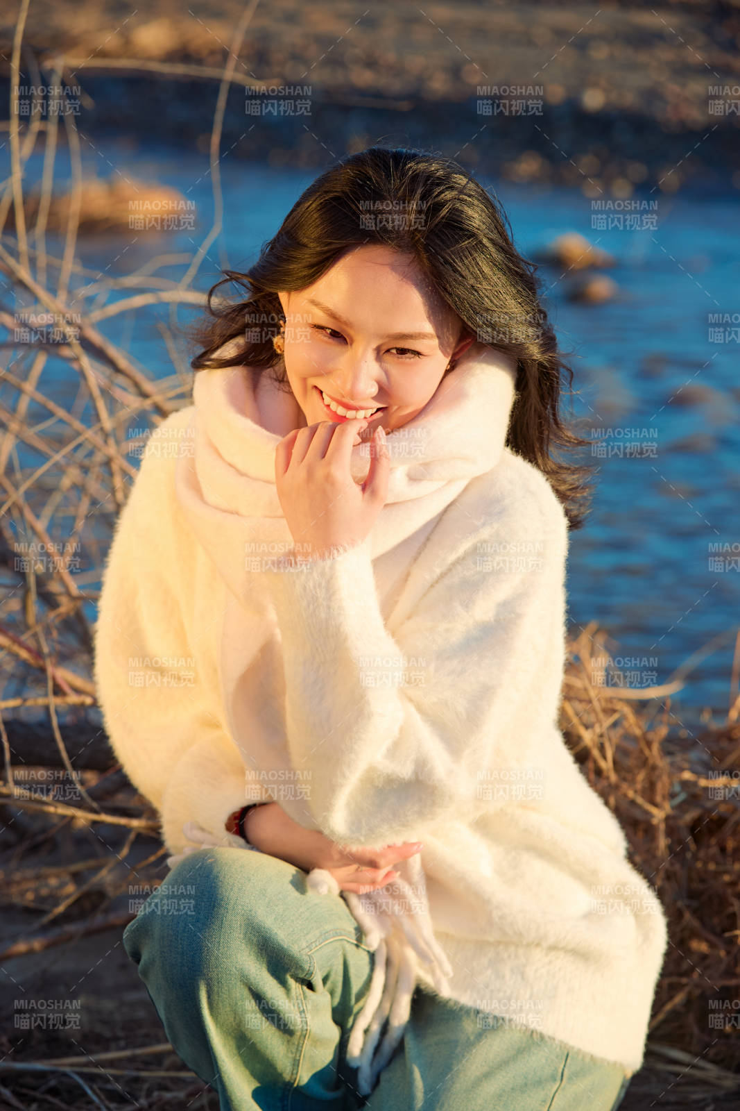 秋天在夕陽下的原野河邊拍照的美女