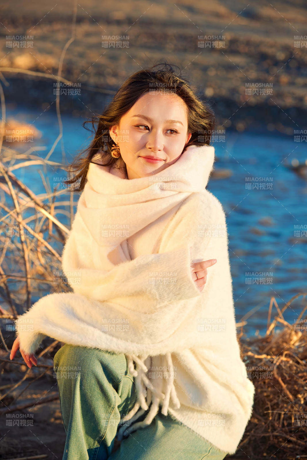 秋天在夕陽下的原野河邊拍照的美女