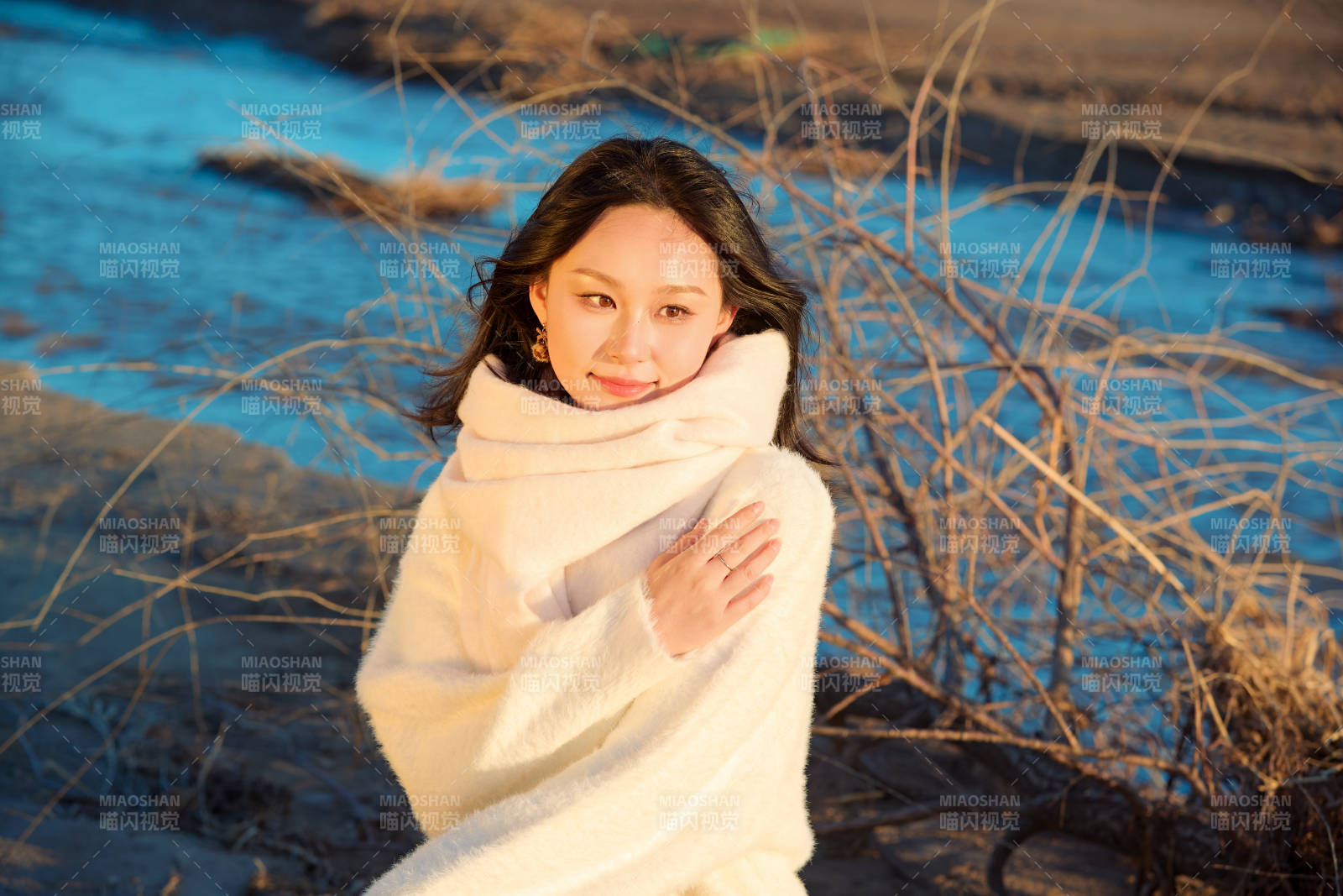 秋天在夕阳下的原野河边拍照的美女