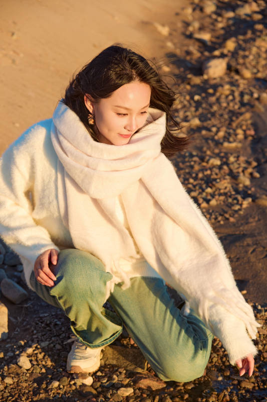 深秋夕阳下在户外河水边的东方女性