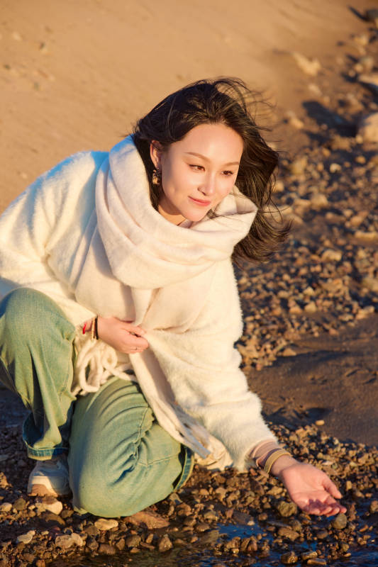 深秋夕阳下在户外河水边的东方女性