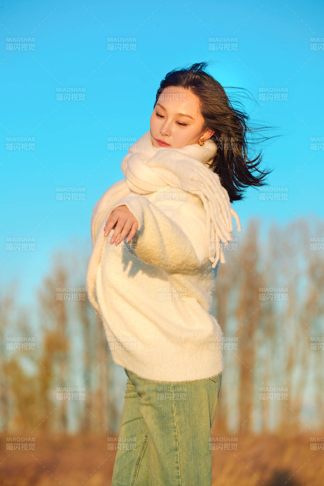 深秋夕阳下在户外河水边的东方女性