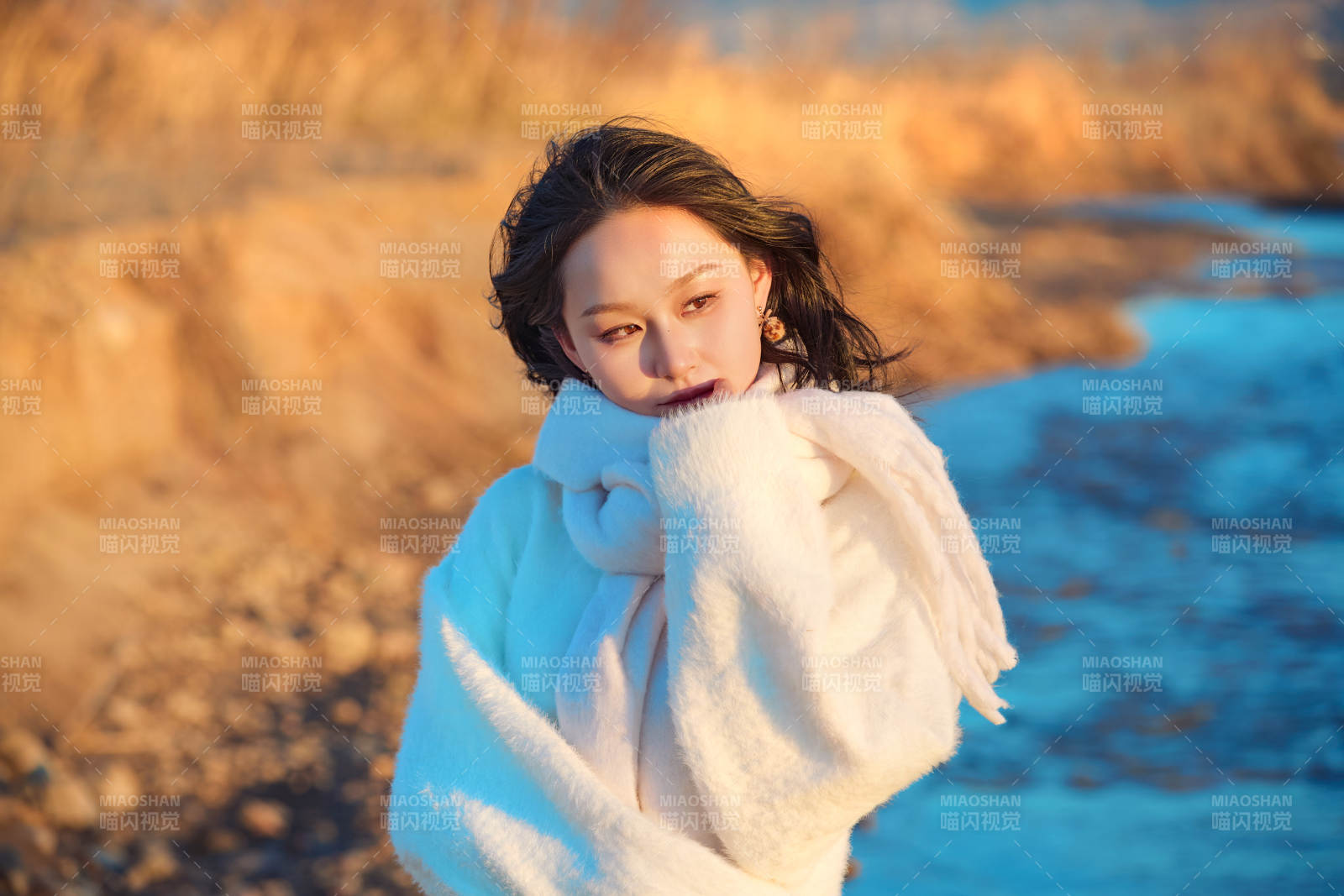 深秋夕阳下在户外河水边的东方女性