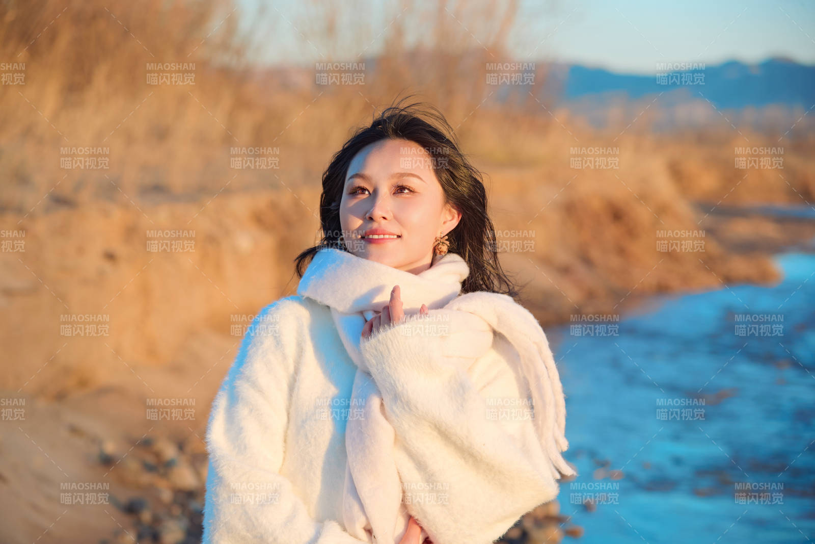 深秋夕阳下在户外河水边的东方女性