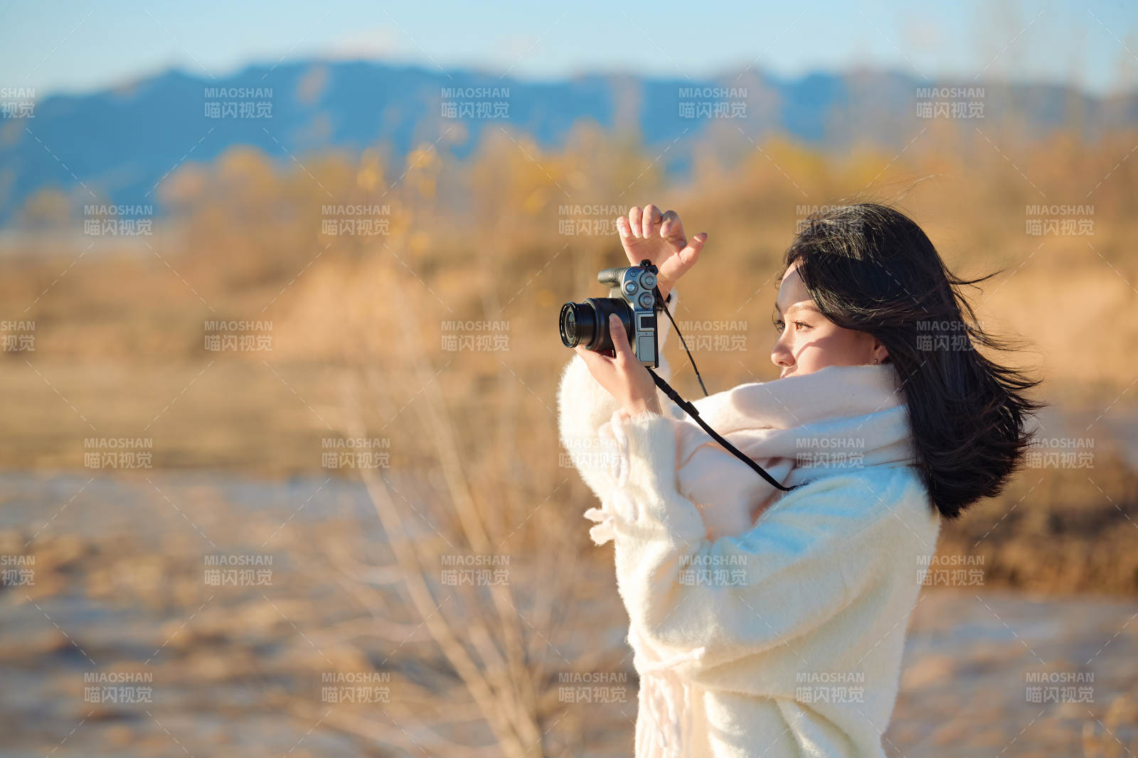 拿著相機的美女攝影師在深秋的戶外拍攝