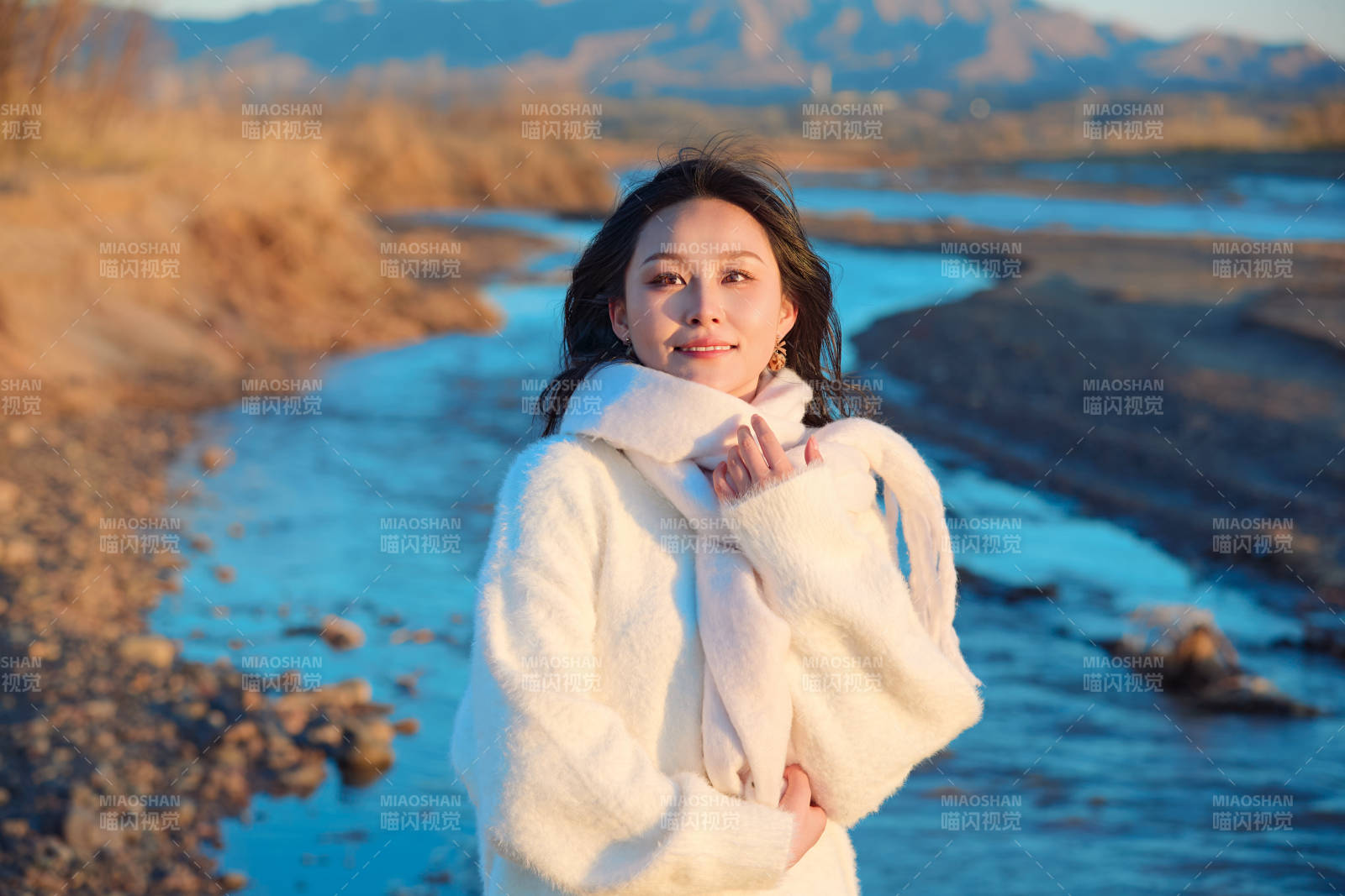 深秋夕阳下在户外河水边的东方女性