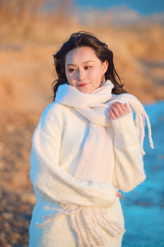 深秋夕阳下在户外河水边的东方女性