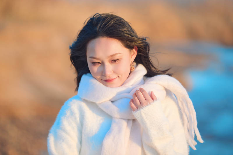 深秋夕阳下在户外河水边的东方女性