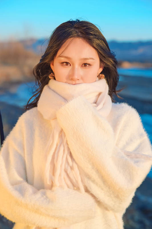 深秋夕阳下在户外河水边的东方女性