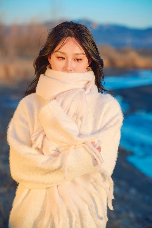 深秋夕阳下在户外河水边的东方女性