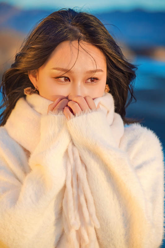 深秋夕阳下在户外河水边的东方女性