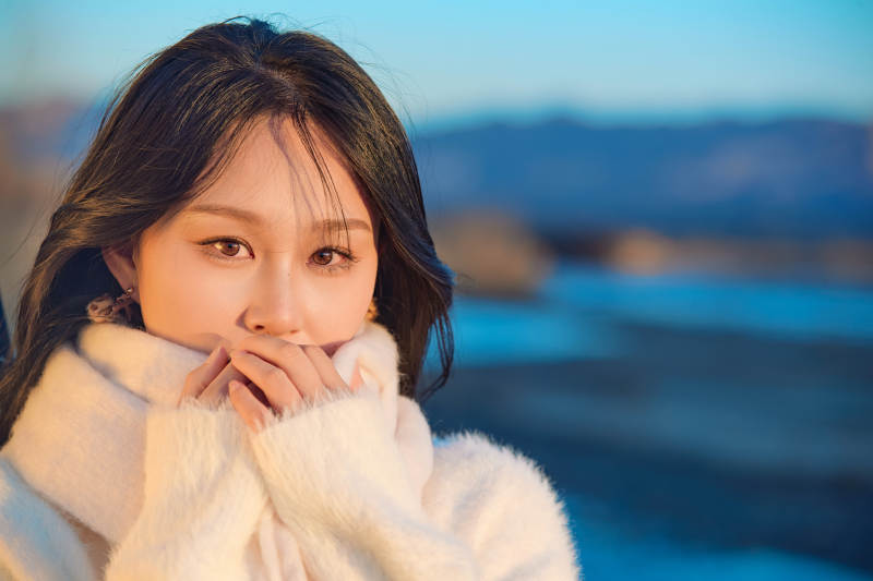 深秋夕阳下在户外河水边的东方女性