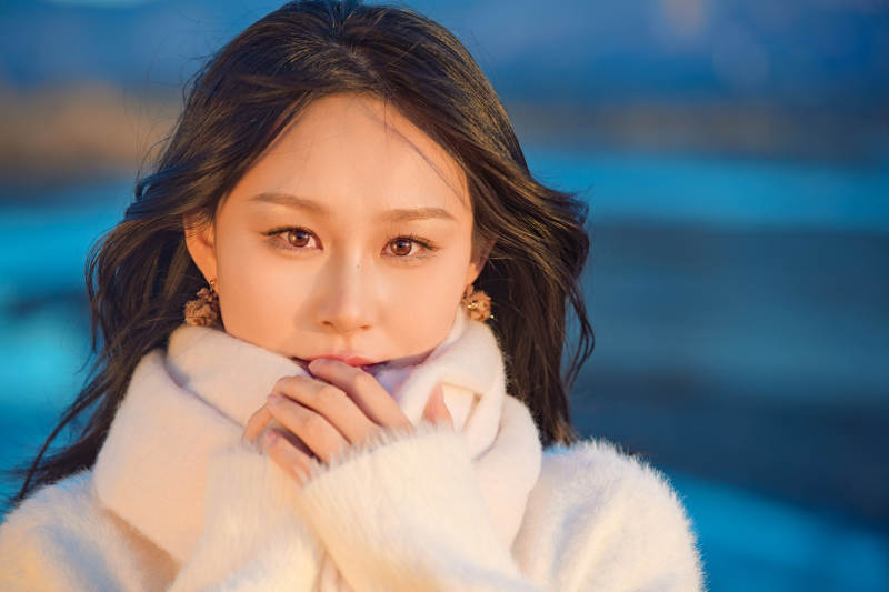 深秋夕阳下在户外河水边的东方女性