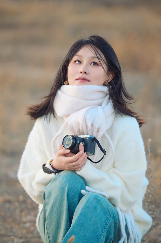 深秋户外手持相机的亚洲女性摄影师