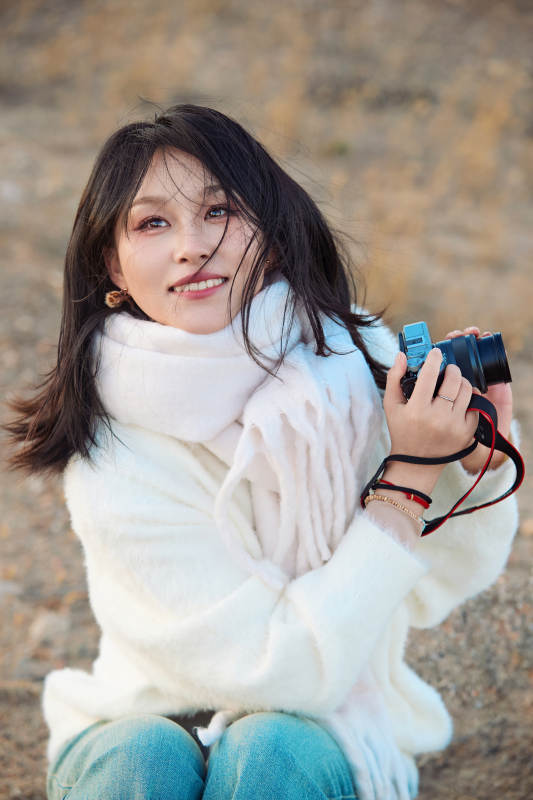 深秋户外手持相机的亚洲女性摄影师