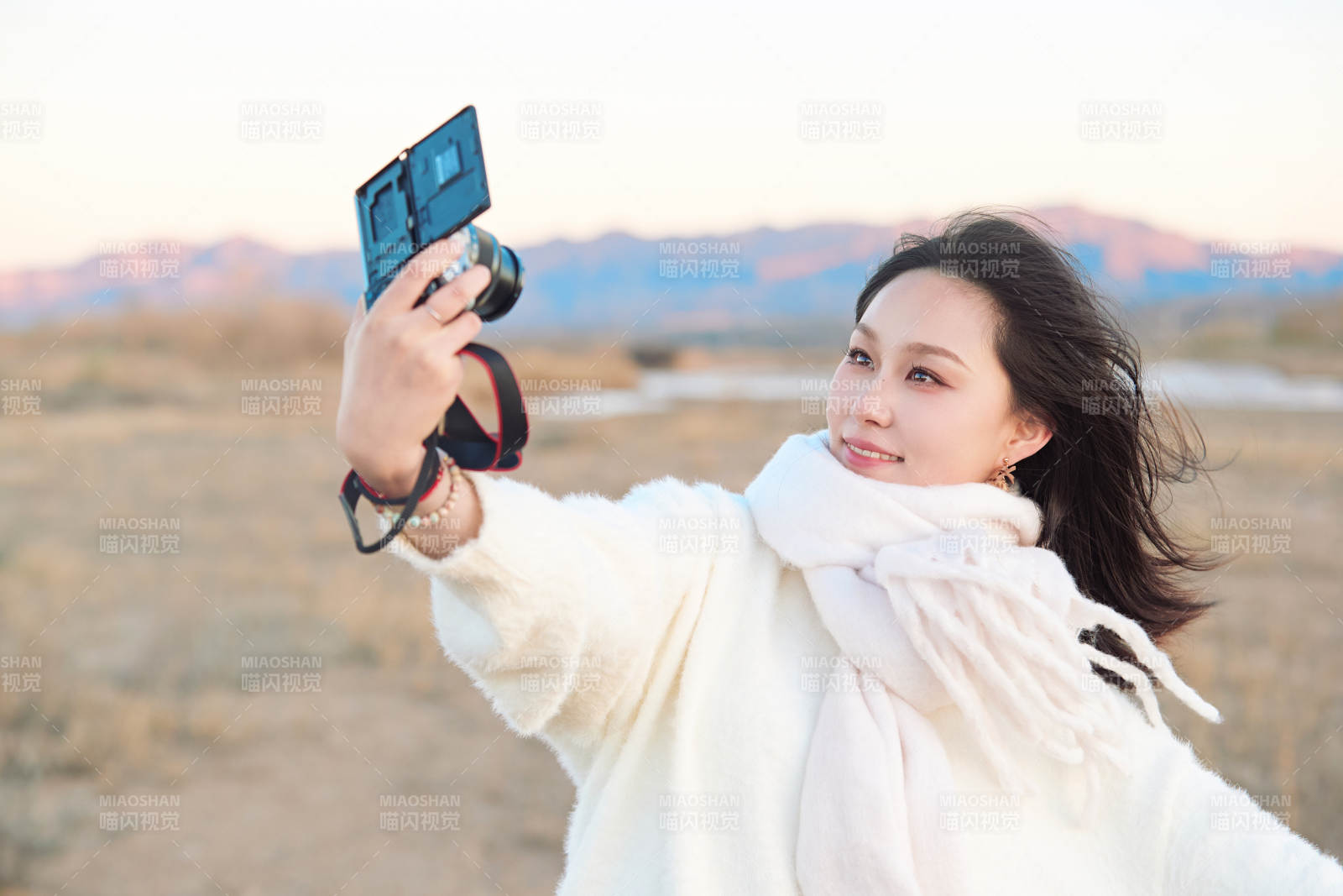 秋天夕陽下手持相機自拍的亞洲美女