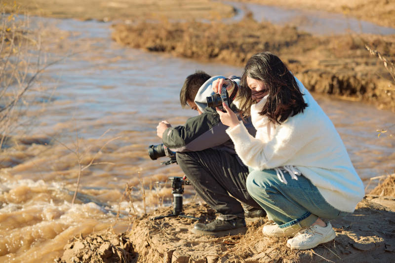 深秋户外进行拍摄的两位亚洲摄影师