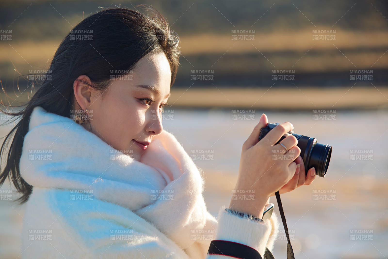 拿着相机的美女摄影师在深秋的户外拍摄