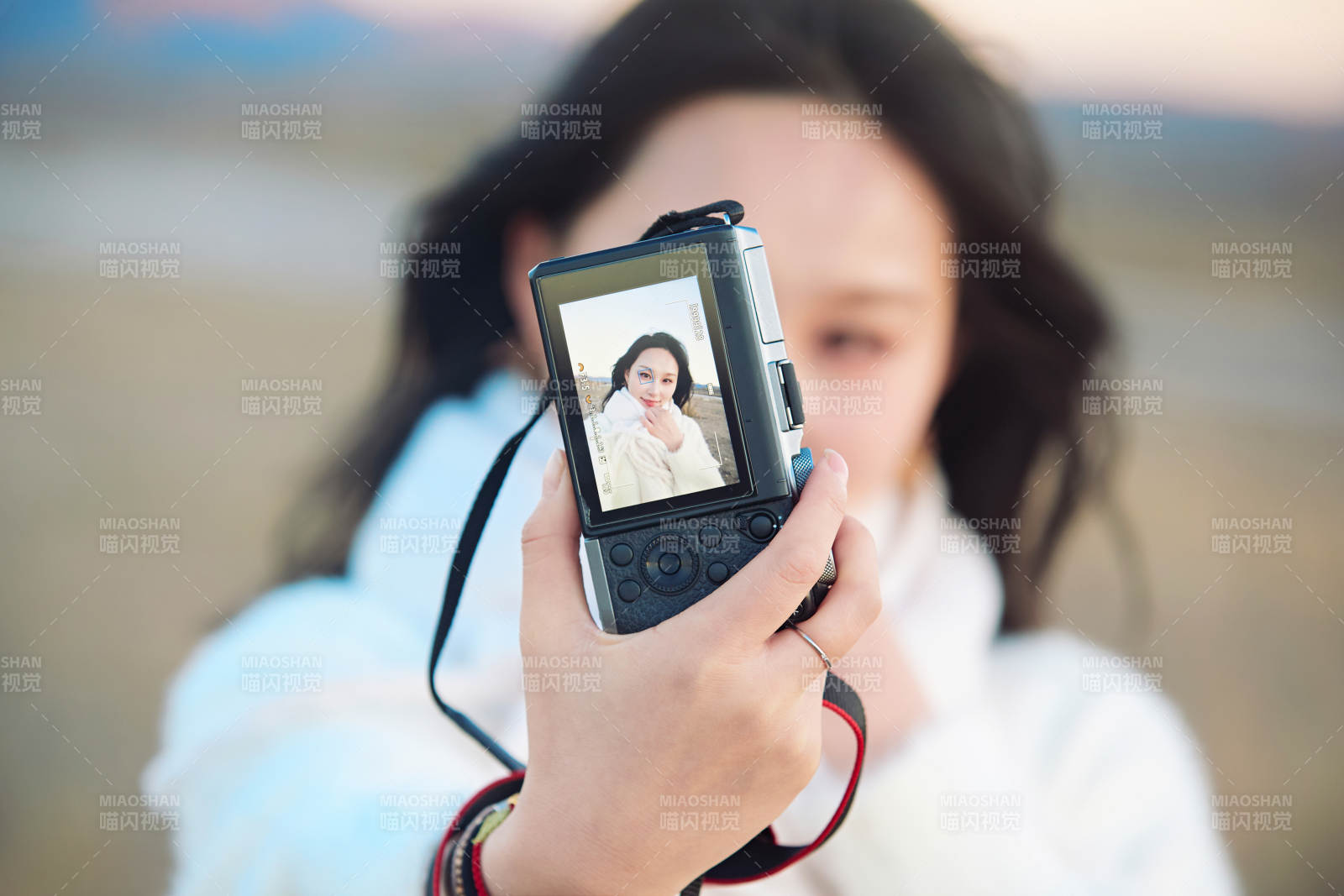 秋天夕阳下手持相机自拍的亚洲美女