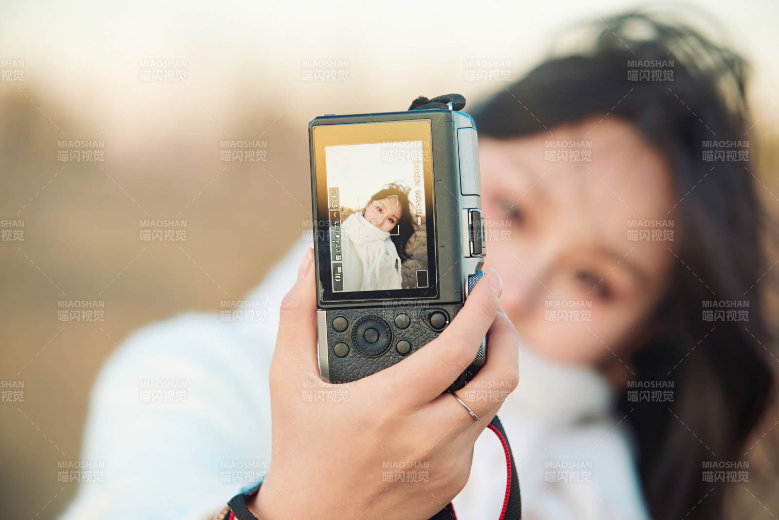 秋天夕陽下手持相機自拍的亞洲美女