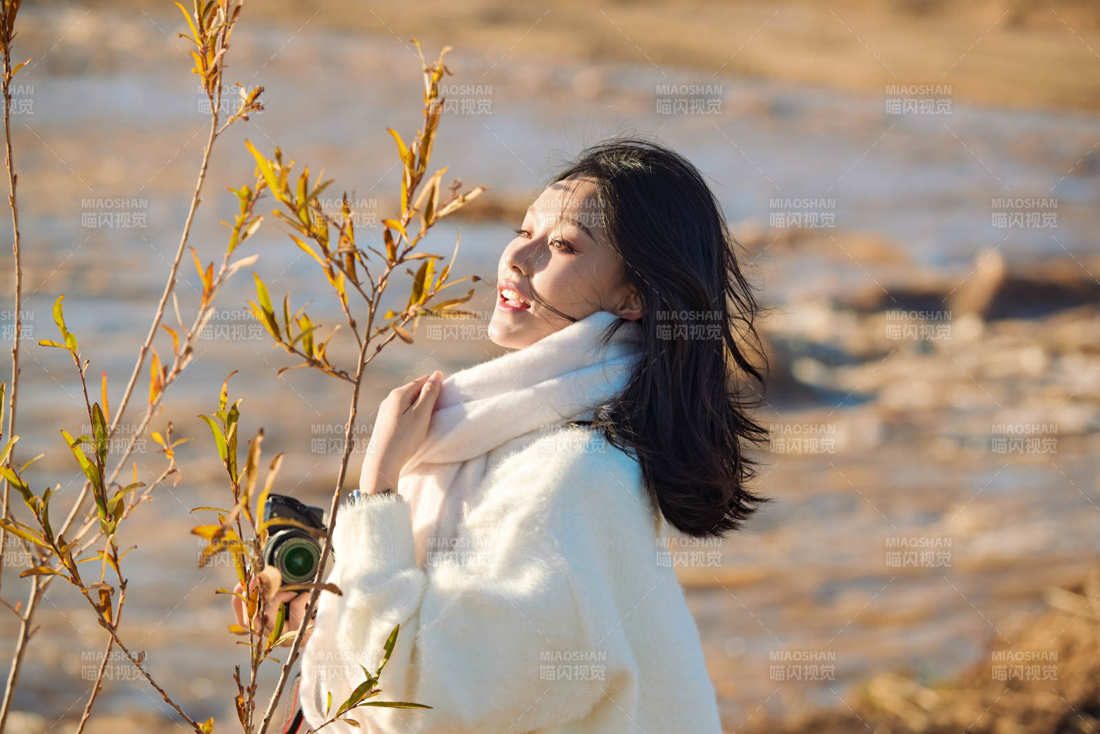 拿着相机的美女摄影师在深秋的户外拍摄