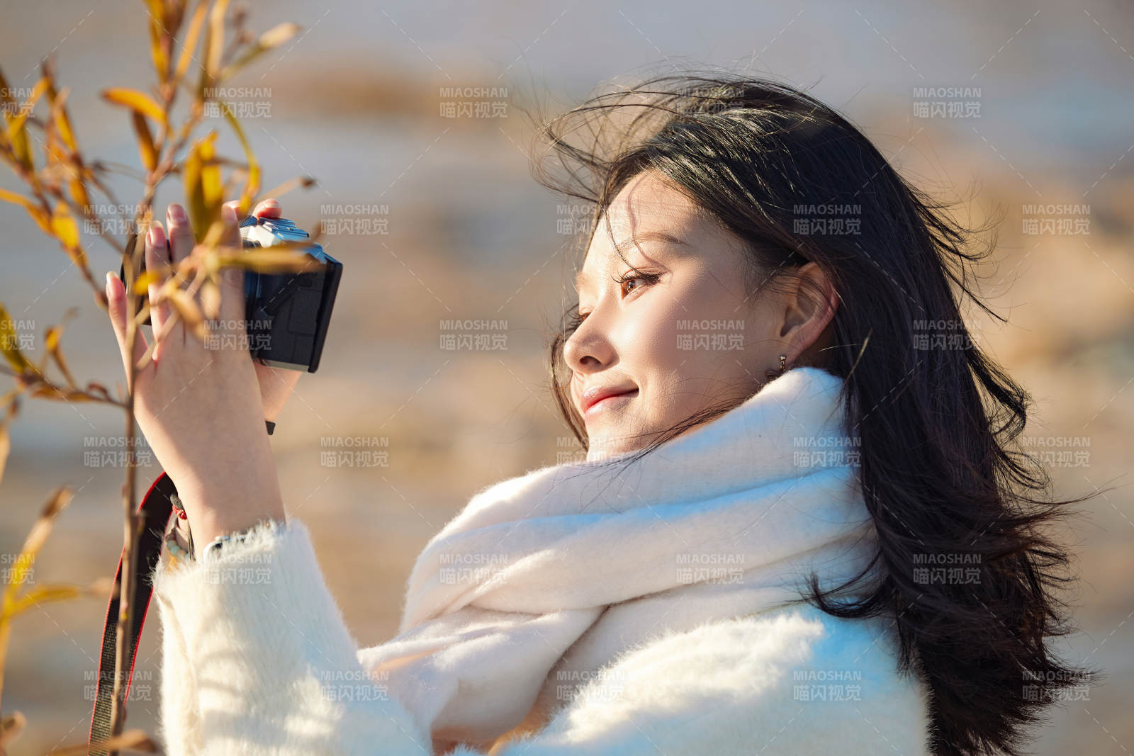 拿着相机的美女摄影师在深秋的户外拍摄